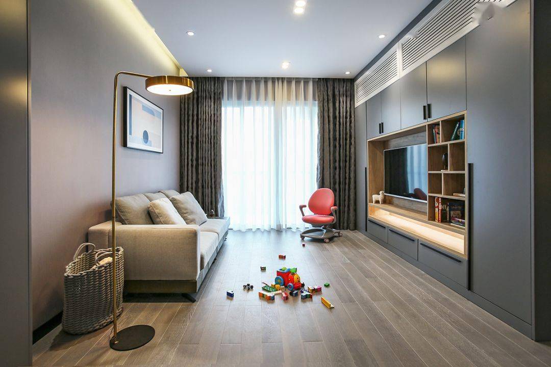 今天分享的是一套建筑面積102平米的現(xiàn)代輕奢風(fēng)三居室案例，屋主夫妻和女兒、母親一家四口人居住，整體來說是比較緊湊的剛需三房案例，設(shè)計(jì)師以輕松、時(shí)尚的灰色調(diào)作為主色，搭配格調(diào)滿滿的木質(zhì)家具，營(yíng)造出簡(jiǎn)約、輕奢的感覺。    平面布置圖    入戶玄關(guān)和餐廳連在了一起，利用了入戶門側(cè)方的墻面來做上一整墻的柜子，把鞋柜和餐邊柜結(jié)合在一起使用，更為省空間。    復(fù)古的木質(zhì)餐桌椅到灰色調(diào)的背景，金屬質(zhì)感的吊燈，整個(gè)餐廳看起來非常有格調(diào)感。在餐桌椅側(cè)方加上隔板的設(shè)計(jì)，增強(qiáng)儲(chǔ)物能力。    位于餐廳另一側(cè)的就是客廳空間了，客廳的茶幾被舍棄，中間留空方便作為孩子的娛樂區(qū)，米色布藝沙發(fā)和暖灰色背景墻讓人感覺更加溫馨。    客廳的電視背景墻則是被利用起來做了收納，整墻的柜子留空電視周邊的部分區(qū)域，加上藏光之后使用更方便，看起來也更大氣。    廚房?jī)?nèi)部的櫥柜延續(xù)了客餐廳的柜子顏色，深灰色的大理石墻磚搭配灰色的啞光地磚，整個(gè)廚房看起來很有現(xiàn)代感。    臥室選擇了以藍(lán)灰色為主，在臥室頂部吊頂內(nèi)加上藏光，用吊燈、臺(tái)燈等代替主燈，讓臥室看起來更為簡(jiǎn)潔。    在主臥室里還有一個(gè)迷你的衣帽間，U字形布局的柜子把角落空間充分用上。衣帽間外的床頭柜改成了梳妝臺(tái)，使用起來更加方便。    老人房選擇了榻榻米床組合衣柜和書桌的設(shè)計(jì)，榻榻米的安全性會(huì)更高一些，加上一張書桌也方便屋主母親看看書。    衛(wèi)生間內(nèi)部是三角形的布局方案，鉆石形的淋浴房做在了轉(zhuǎn)角處，兩側(cè)擺放洗手臺(tái)和馬桶。洗手臺(tái)上方的鏡柜做了藏光的設(shè)計(jì)，看起來更時(shí)尚。